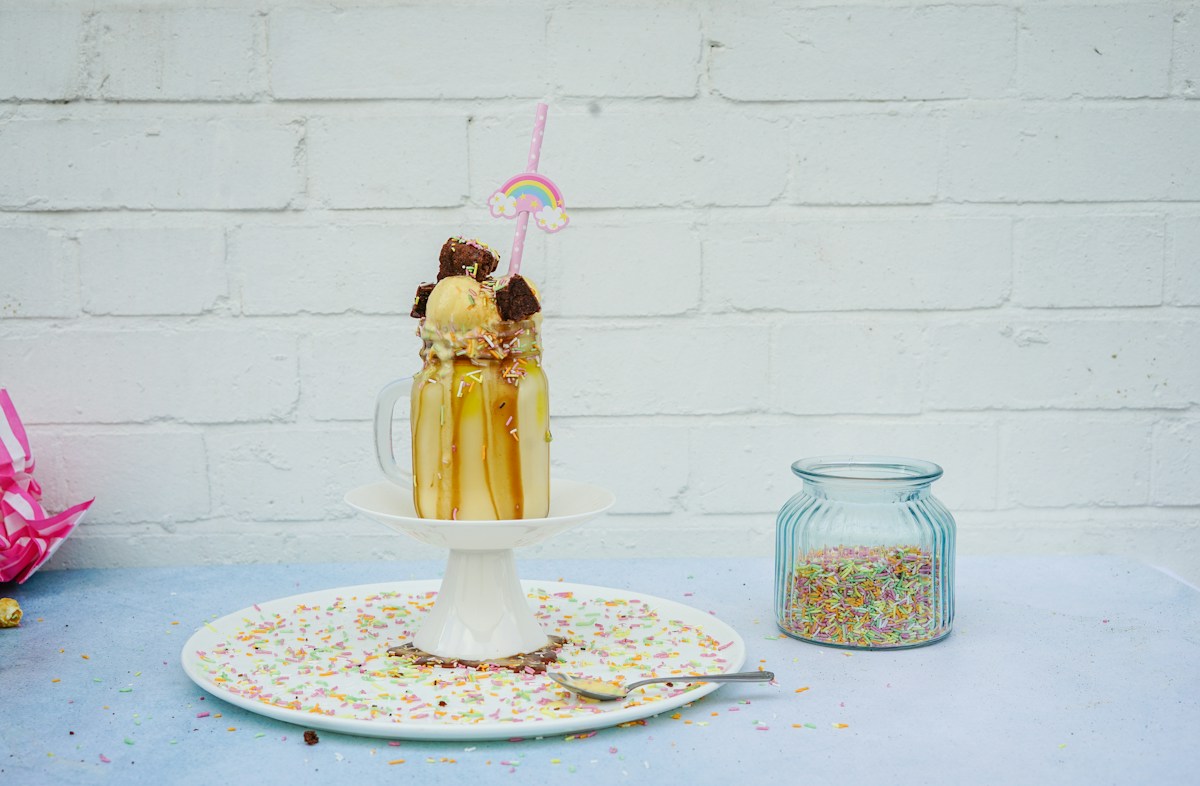 Caramel milkshake with cream and sprinkles