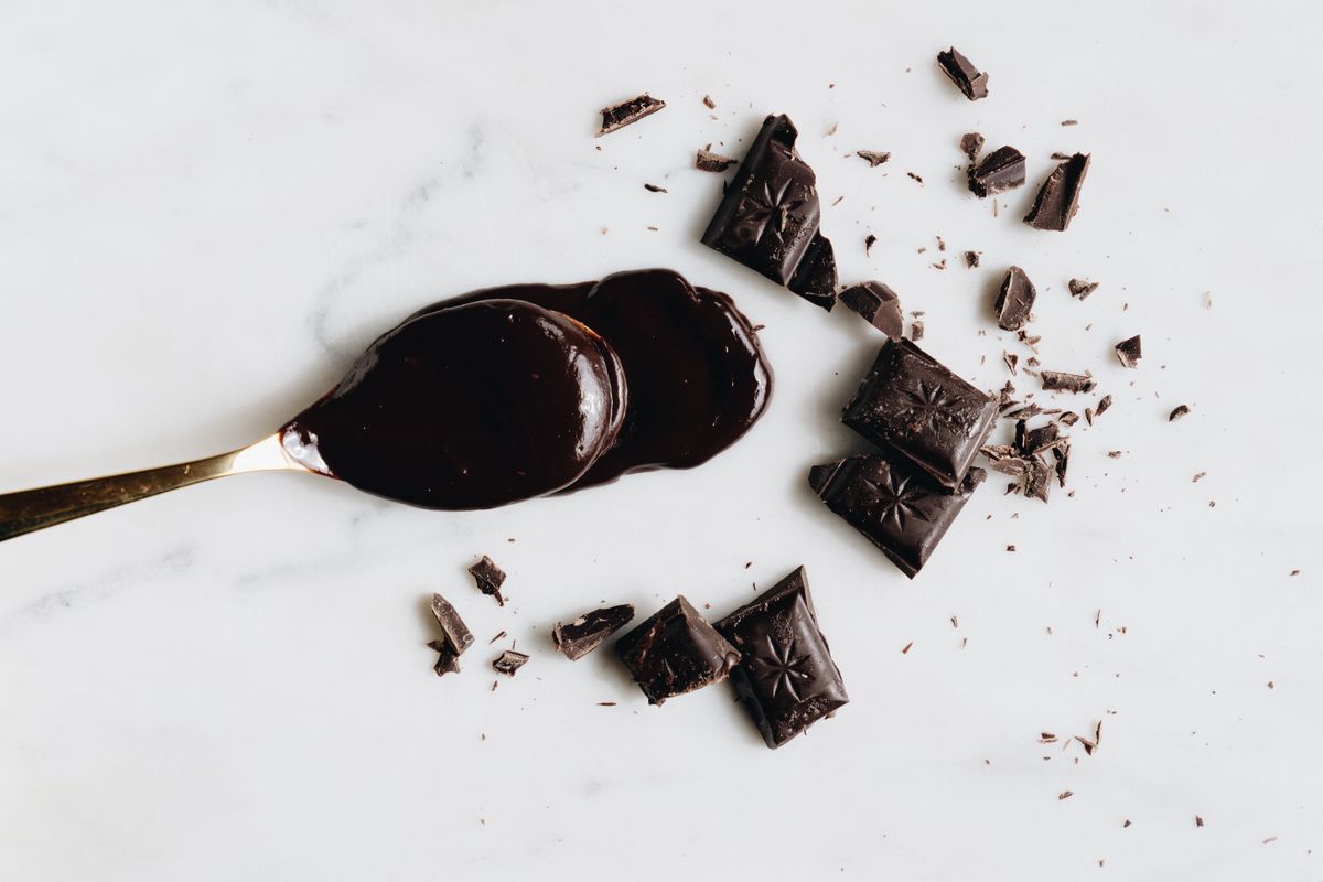 Dark chocolate pieces and melted chocolate on a spoon
