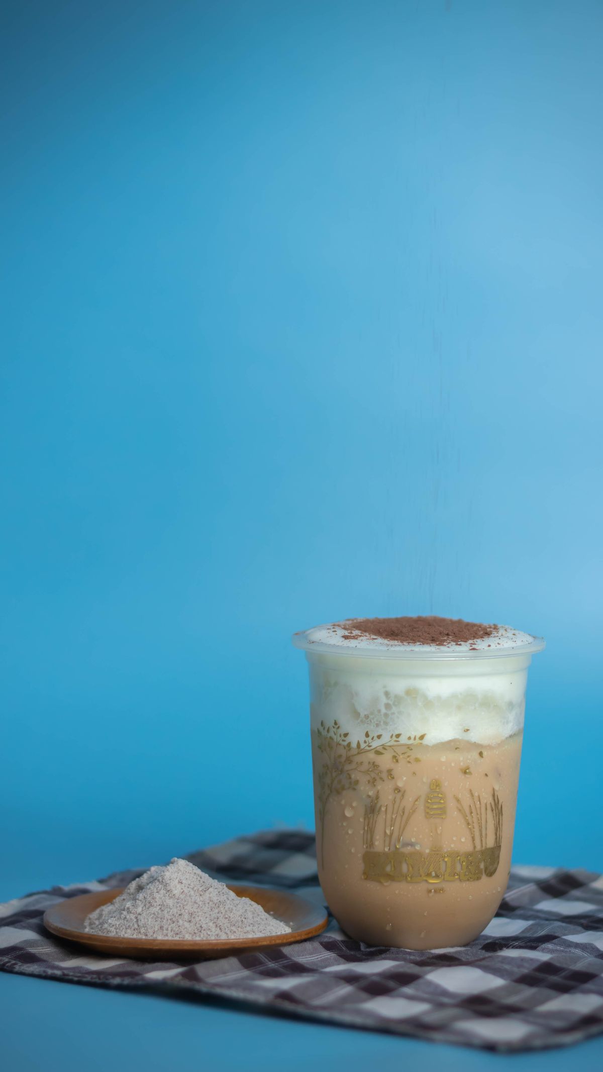 Iced coffee frappe topped with cream and cocoa