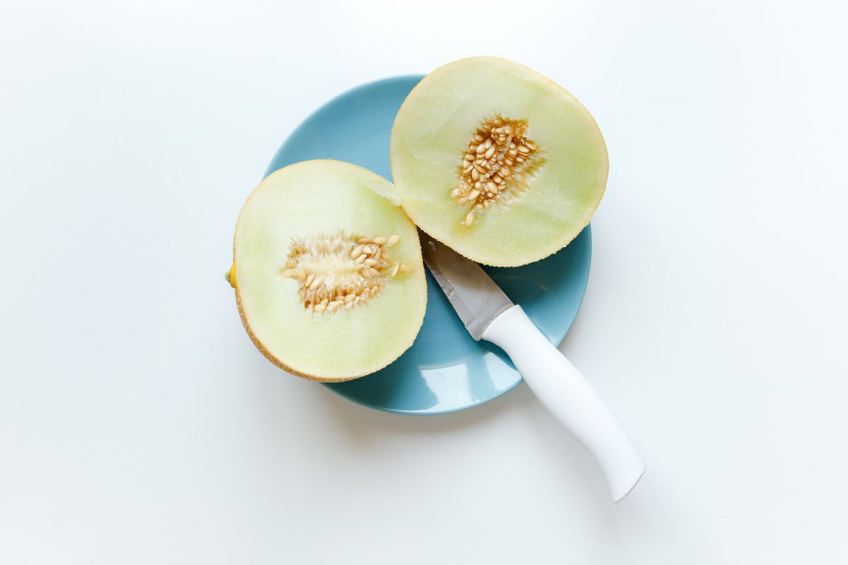 Halved honeydew melon on a blue plate
