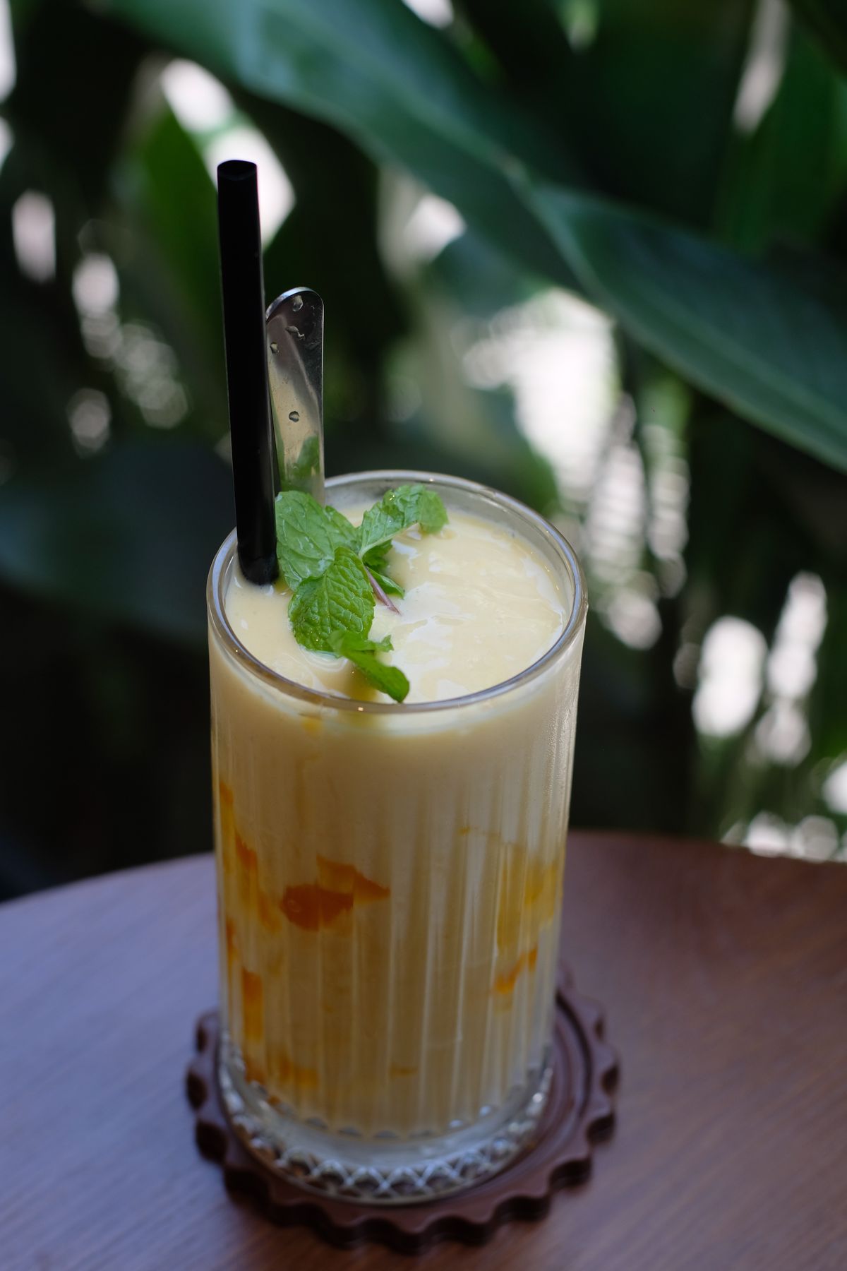 Mango smoothie with mango pieces and mint garnish