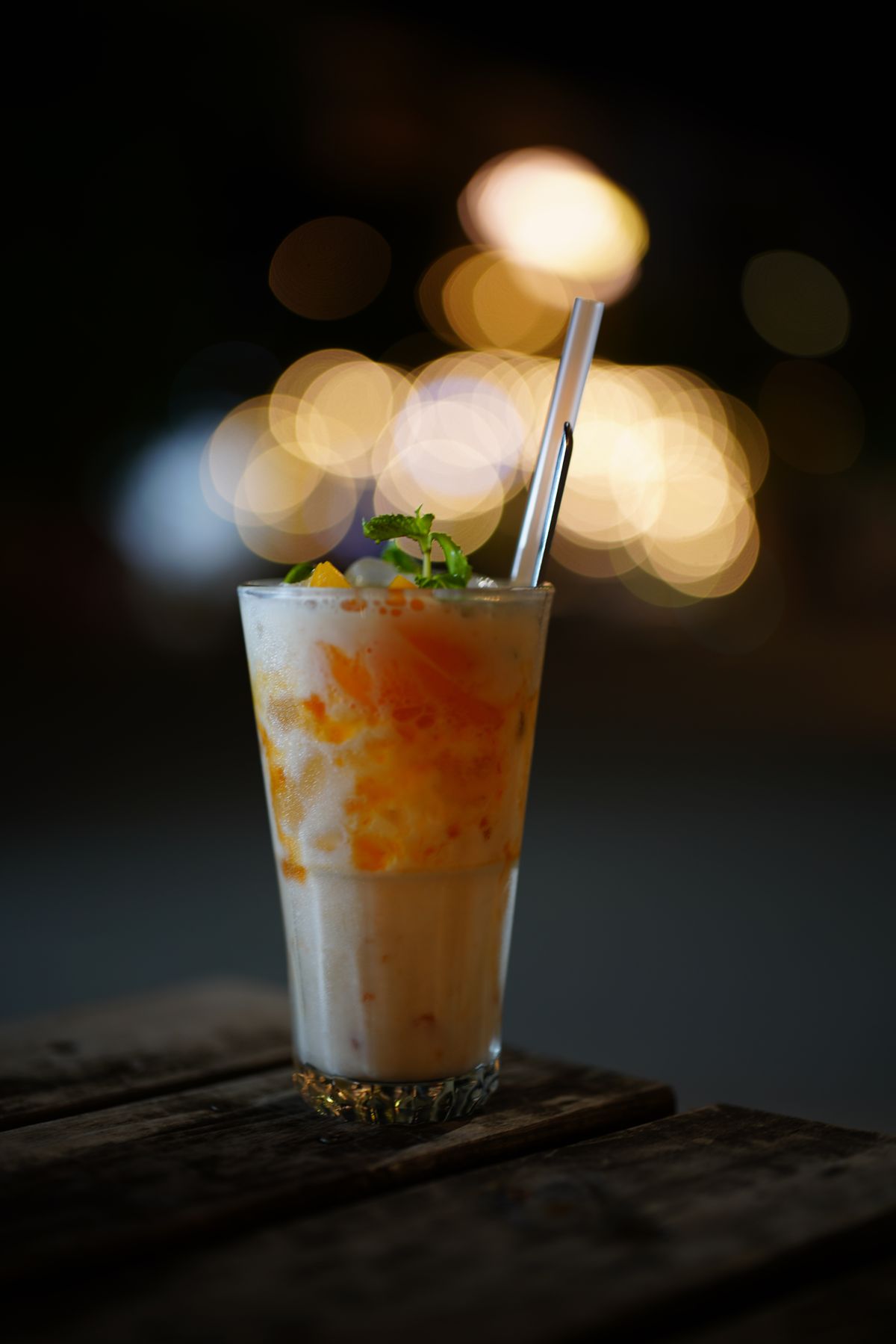 Mango milkshake in a glass with mint garnish