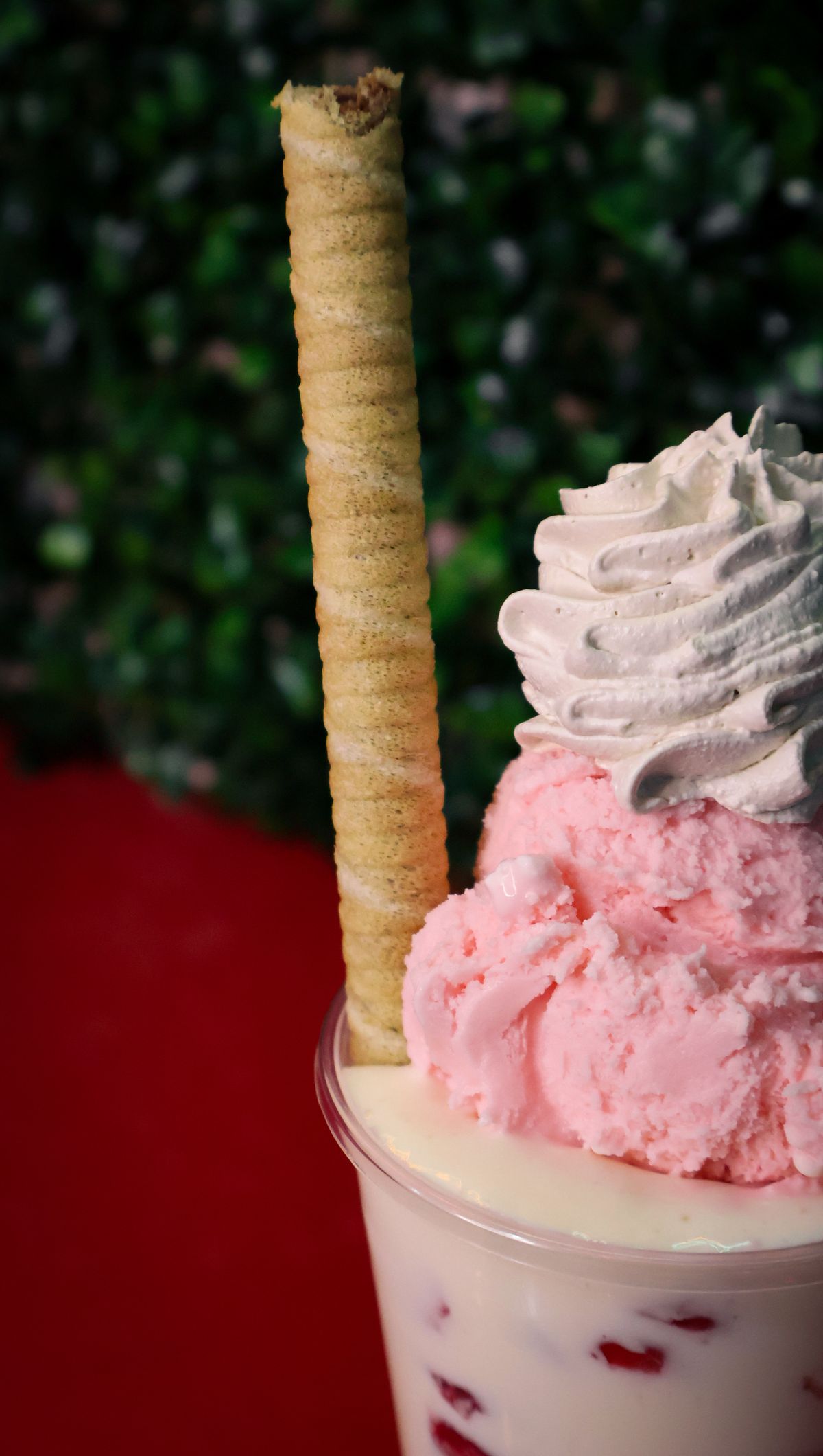 Strawberry ice cream sundae with cream and a wafer